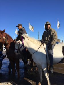 Young men on horseback assembling as they prepare to lead the way in rebuilding the Sacred Hoop